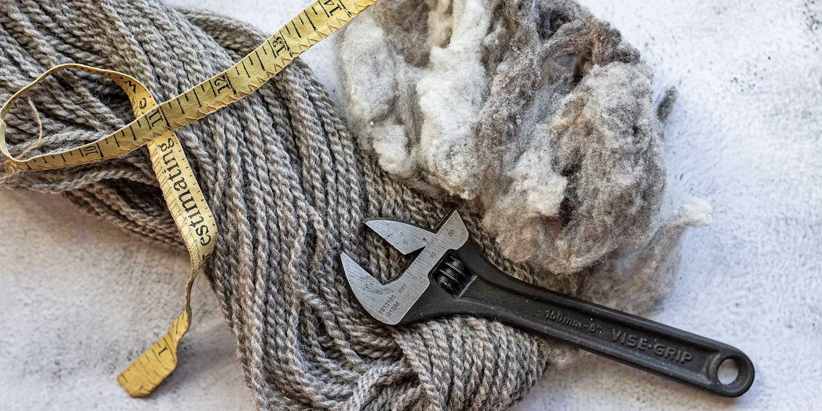 Wool fibers and yarn with measuring tape and wrench